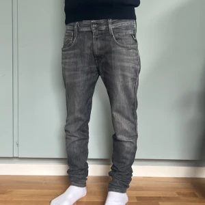 Replay Bronny svarta slim jeans - Snygga svarta Replay Bronny jeans i super slim fit. Jeansen har en mörk tvätt med lätt slitning, klassiska fem fickor och diskret logga på bakfickan. Perfekta om du gillar en tightare passform och stilren look.