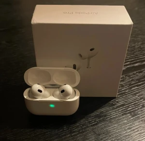 Apple AirPods Pro med laddningsetui - Säljer ett par vita Apple AirPods Pro med trådlöst laddningsetui. Hörlurarna har en stilren och kompakt design, levereras med originalförpackning, laddningskabel och extra öronproppar. Perfekta för musik, samtal och träning.