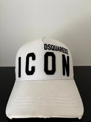 Dsquared Keps - Vit dsquared keps, helt oanvänd. Har aldrig använt den och den har suttit inne i garderoben ganska länge. Nypris är 2340kr (du kan se de på sista bilden) Mitt pris: 980kr. Hör av dej vid intresse!