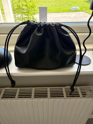 Svart bucket bag med dragsko - Svart handväska