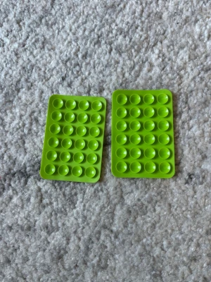 Två gröna sugpropps Octopus mobilgrepp - Säljer två rektangulära pop it-mobilgrepp i starkt grön färg. Fler färger finns på min profil