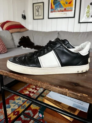Valentino Flycrews - Snygga sneakers från Valentino i svart och vitt läder. Riktigt bra skick med några få skavanker. .                                              Två nitar saknas på vardera sko.                        Extra nitar har satts på.                                              Dm vid frågor eller fler bilder!