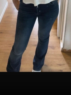 Mörkblå bootcut jeans - Säljer ett par mörkblå bootcut jeans med klassisk femficksdesign och normal midja. Jeansen har en lätt utsvängd passform nedtill och är tillverkade i ett stretchigt denimtyg som sitter snyggt på kroppen. Perfekta till en avslappnad och trendig look.