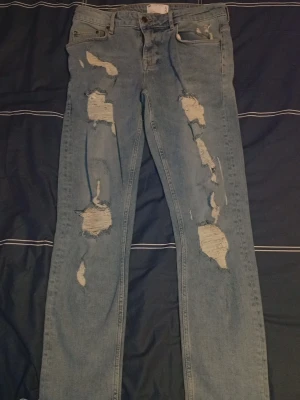 Ljusblå slitna jeans med hål - Säljer ett par ljusblå jeans 