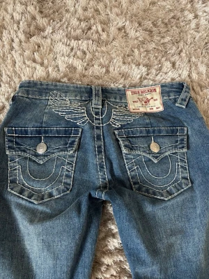 True Religion low waist jeans  - Supersnygga true religion jeans! Lågmidjade, flared med snygga fickor och vit broderad logga bak. Inga tecken på användning alls, nypris 1599kr. Storlek 23  Skriv vid frågor ☺️