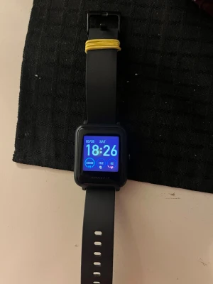 Svart Amazfit Bip smartklocka - Snygg svart Amazfit Bip smartklocka med fyrkantig display och silikonarmband. Klockan har färgskärm och flera funktioner som stegräknare, pulsmätare och notiser. Perfekt för dig som vill ha koll på både träning och vardag.
