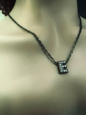 By prisförslag- Halsband med bokstav E och pärlor - Snyggt halsband med en kedja i mörk metall och ett hängsmycke i form av bokstaven E. Bokstaven är dekorerad med glittrande pärlor som ger en cool och personlig touch. Perfekt accessoar för dig som vill sticka ut med din initial.