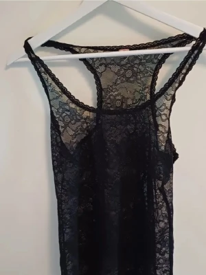 Svart spetstopp med blommönster - Säljer en svart spets topp i genomskinlig spets med blommönster. Linnet har rundad halsringning. Skriv om ni har frågor ❤️