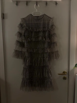 By Malina volang spets klänning - Super fin klänning från By Malina i en grå unik färg. Har klippt bort kragen som stack upp då jag inte tyckte det såg snyggt ut därav priset. Annars i super skick då den bara är använd en gång. (Nypris ca 2500kr)  Hör av dig om du har några frågor! 💗🫶🏼