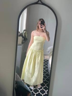 Ljusgul långklänning med smala axelband, gul klänning - Säljer en citrongul så fin långklänning med smala axelband och rynkad midja. Lätt att både klä upp och ner och perfekt till sommaren 