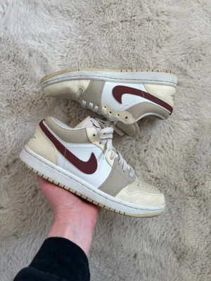 Nike Air Jordan 1 Low Desert Khaki Red - 38 - Säljer dessa Air Jordan 1 Low sneakers från Nike i modellen desert khaki red, storlek 38. De är använda 2 gånger och är i perfekt skick. Perfekt för dig som letar efter ett par snygga vår/sommar sneakers!😁Unisex.