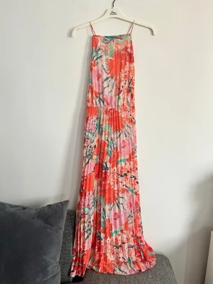 Blommig långklänning  - Superfin blommönstrad maxiklänning i plisserad chiffong från H&M. Perfekt för sommarens alla tillfällen!