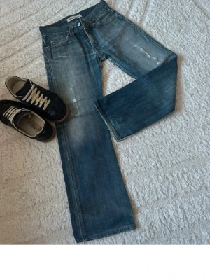 Levi's 506 - Säljer ett par klassiska blå jeans från Levi's (506) med slitna detaljer. Jeansen har fyra fickor, knappgylf och en snygg tvättad look. Perfekta för en avslappnad stil och passar till det mesta. Materialet är bomull.