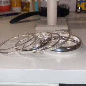 Snygga silverfärgade bangles armband - ❗️ KÖPT FÖR 300 ❗️ Säljer ett set med sex stilrena bangles i silverfärg. Armbanden har olika mönster och ytor, vissa är släta medan andra har graverade detaljer. 