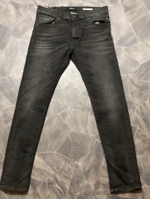 Svarta skinny fit jeans från Replay - Snygga svarta slim fit jeans från Replay med klassisk femficksmodell och diskreta slitningar framtill. Jeansen har en stilren look med Replay-logga på bakfickan och patch i midjan. Tillverkade i stretchigt denim för extra komfort.