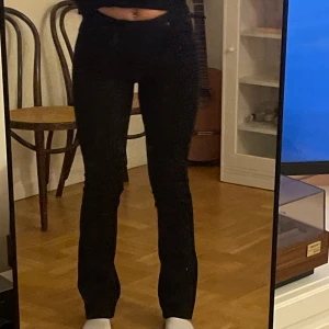Svarta bootcut jeans från Lee - Säljer ett par svarta bootcut jeans från Lee med klassisk femficksmodell och hög midja. Jeansen har en snygg, figurnära passform upptill och utsvängda ben. Perfekta för dig som gillar en tidlös och trendig look. De är nya