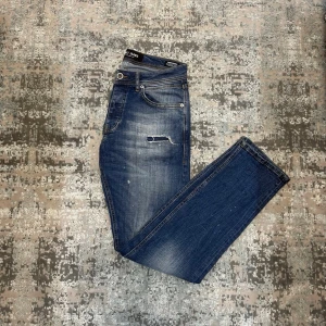 Blå fina jeans  - Säljer ett par blå jeans med snyggt slitna detaljer och tvättad look. Jeansen har klassisk femficksmodell, normal midja och smal passform. Materialet är denim med stretch för extra komfort. Perfekta för en avslappnad och trendig stil. OBS fläck på baksidan av benet som det syns på bild 6, inget synligt dock.