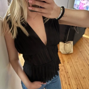 Svart topp  - Snygg svart topp djup v-ringning och volangkant nedtill. Från Zara i storlek S. ☀️