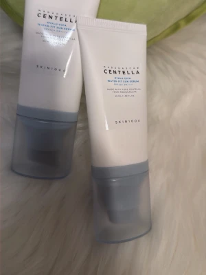 SKIN1004 Centella Water-Fit Sun Serum - SKIN1004 Centella Water-Fit Sun Serum är en solkräm i tub med SPF50+ PA++++. Tuben är vit med gråblått lock och innehåller 50 ml. Innehåller centella från Madagaskar och har en lätt, återfuktande formula som passar för daglig hudvård.