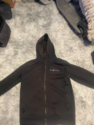 Sail Racing Hoodie - Säljer en svart hoodie från Sail Racing med dragkedja. Tröjan är Solbränd