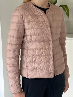 Uniqlo Ultra Light Down jacka XS, rosa - Uniqlo Ultra Light Down jacka för dam i fint skick, storlek XS. Den har några mindre märken framtill, se närbild, men de syns bara vid nära granskning.  Går att rulla ihop så den få plats i en ficka eller i handväskan.