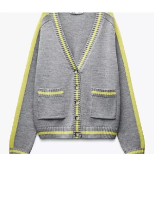 Grå cardigan med gula detaljer - Snygg grå cardigan med gula ränder längs kanterna och ärmarna. Koftan har två framfickor och knäppning framtill. Ribbstickade muddar och v-ringad hals ger en avslappnad look. Perfekt för lager på lager och enkel att matcha.