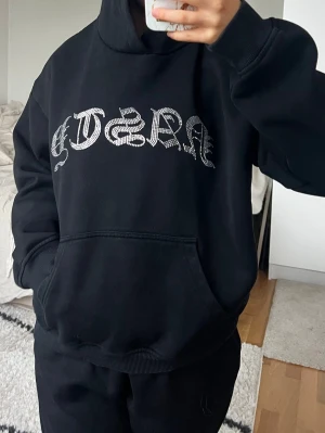Hidden Cult  - Svart Hidden Cult huvtröja. Storlek M i fint skick. På framsidan finns en stor strassdekor med texten 'NASTY' i gotisk stil. Tröjan har en loose passform och är tillverkad i mjukt bomullsmaterial, perfekt för chill dagar. Har även tillhörande mjukisbyxor i en annan annons 🖤   
