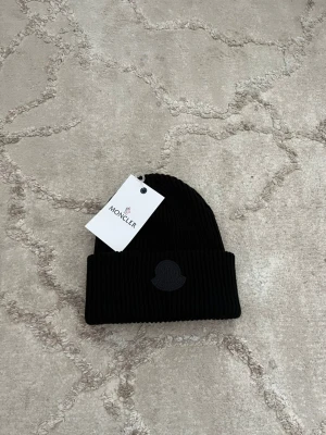 Svart unik mössa - Säljer en mycket fin och unik mössa i färgen svart. Den är helt ny med tags på och perfekt nu under vintern.