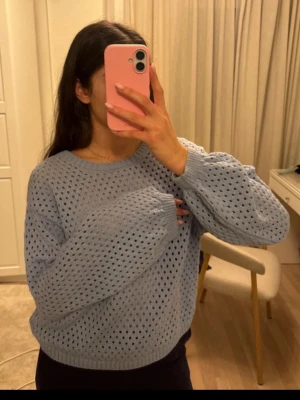 Ljusblå stickad tröja  - Ljusblå stickad tröja från Lindex med hålmönster och rund halsringning. Tröjan har ribbade muddar vid ärmslut och nederkant, och är tillverkad i ett mjukt material. 