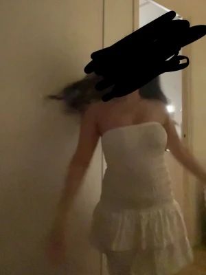 Vit axelbandslös kort klänning - Säljer en söt vit klänning med smock upptill och volang nertill. Storlek: S, med prislapp kvar! Den är endast testad! Perfekt sommarklänning!