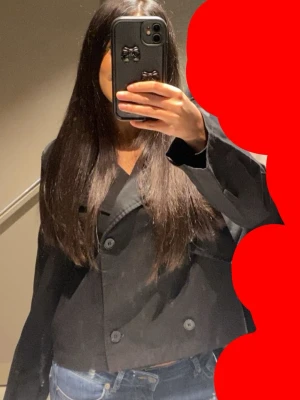 Svart cropped trenchcoat  - Svart cropped trenchcoat med dubbelknäppning. Fick den i födelsedagen förra året och den har inte kommit till så mycket användning. Vill ha ett högt bud på denna men pris kan alltid diskuteras. 
