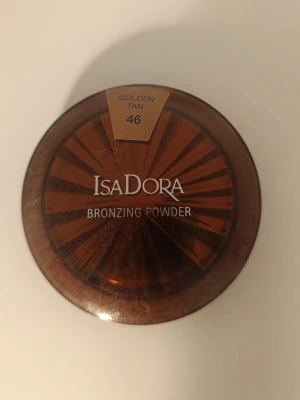Bronzing Powder 46 Golden Tan - Den är ganska så himla använd som ni ser på bilden därmed priset, kan även gå med på att sänka pris. Bronzer från Isadora i nyansen 46 Golden Tan. Kommer i en rund, brun plastförpackning med transparent lock. Perfekt för att ge huden en solkysst look och definiera ansiktet.
