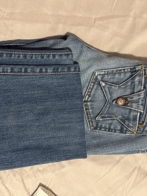 Blå jeans low waist från People's Liberation - jättesnygga low waist jeans med stjärnor på bakfickorna.