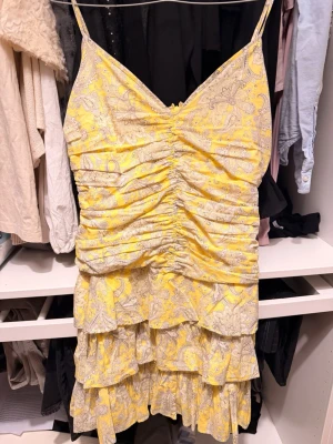 VOLANGKLÄNNING - Vacker volangklänning i gul och beige/grå mönster. Den är så fin men lite för stor för mig!🥰🥰🥺Aldrig använd