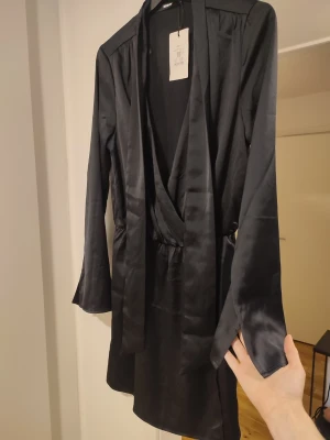 Svart "siden" klänning storlek S - Vacker klänning som känns siden-aktig i tyget. Storlek S. Ord pris 499kr. Helt ny med lappar kvar!