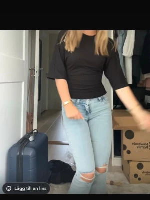 Jeans från Nelly - Säljer ett par ljusblå jeans med slitningar vid knäna och snyggt broderade bakfickor i rosa. Det är bootcut jeans. Pris kan diskuteras 