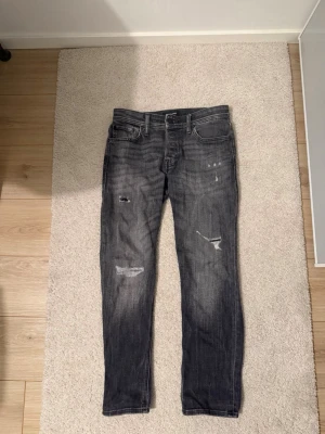 Jack and jones jeans - Säljer ett par svarta Jack and jones jeans med slitningar och tvättade detaljer. Helt nya aldrig använda.