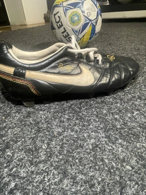 Nike Tiempo Legend R10 fotbollsskor - Snygga Nike Tiempo Legend Ronaldinho 10 fotbollsskor i svart läder med vita detaljer och guldfärgade loggor. Skon är väldigt sällsynt och är limited idetion få i världen som är kvar 