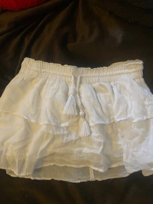 Vit volangkjol från Gina Tricot - Supersöt vit kortkjol från Gina Tricot med volanger.  Storlek 134/140 