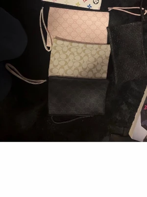 Kuverväska per st  - Säljer en ljusrosa clutch från med klassiskt mönster i rosa. Väskan har en smidig handledsrem och dragkedja upptill. Perfekt för att bära det viktigaste och ge din outfit en lyxig touch.200  kr per vaska !!! Or 900 kr for allt !!!