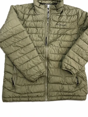Olivgrön pufferjacka från Columbia - Snygg olivgrön pufferjacka från Columbia med quiltad design och hög krage. Jackan har två dragkedjeförsedda fickor och hel dragkedja framtill. Perfekt för kalla dagar tack vare det vadderade materialet som håller värmen.