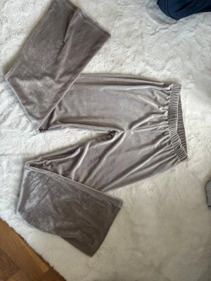 Gråa velourmjukisbyxor ONLY YOUNG - Supermjuka och sköna gråa mjukisbyxor i velour från ONLY YOUNG. Byxorna har resår i midjan och raka ben med avslappnad passform. Perfekta för chill eller myskvällar hemma. Andvänt ett ex antal gånger men ingen riktig skada vad jag ser, pris kan diskuteras. 