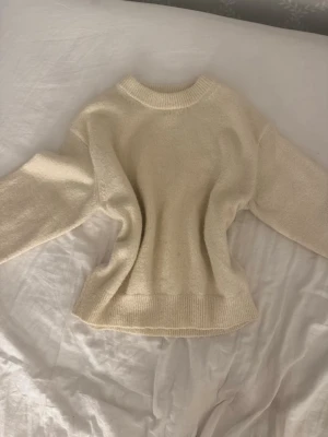 Beige stickad tröja - Mysig beige stickad tröja med rund halsringning och breda, långa ärmar. Tröjan har ribbstickade muddar vid ärmslut och nederkant, vilket ger en avslappnad och trendig look. Pris går att diskutera vid snabb affär