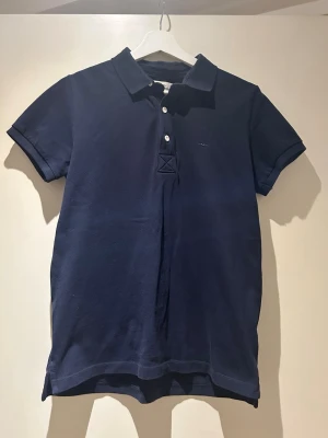 Pikétröja Kappahl herr  - Säljer min brors blå pikétröja, märket är Hampton republic 27 men den är köp på Kappahl. Storlek 170 men passar xs/s. Säljer eftersom den är för liten. Bra skick och inga defekter förekommer. Kom privat för frågor eller fler bilder 