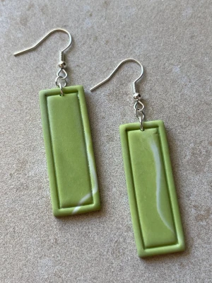 Handgjorda örhängen i grönt – minimalistisk design (silver) - Handgjorda örhängen i polymerlera  Stilren och minimalistisk design i gröna toner – enkla men med tydlig form.  Ca 6 cm långa – lagom storlek som syns utan att bli för stora.  Antiallergiska detaljer Lätta Silverfärgade detaljer (finns även med guldiga detaljer)  Flera par finns  Skriv om du vill se exakt par innan köp  Skickas