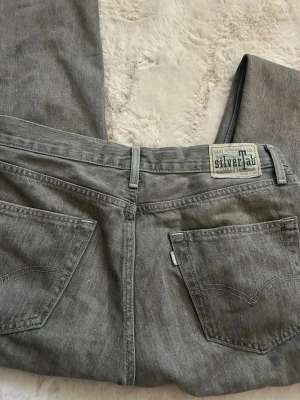 Grå Levi's SilverTab jeans - Ett par gråa Levi's SilverTab jeans med raka ben och klassiska bakfickor. Jeansen har en avslappnad passform och är tillverkade i bomullsdenim. Perfekta för en cool och avslappnad stil.