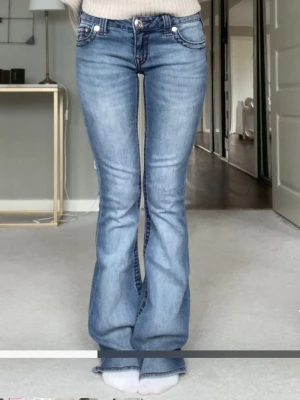 True religion jeans  - Pris kan diskuteras.Snygga blå bootcut jeans med vinröda sömmar och detaljer. I nyskick- nypris ca 1300 Jeansen har en klassisk femficksdesign och lätt utsvängda ben. Perfekta för dig som gillar en retroinspirerad look.