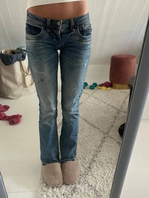 Blå bootcut jeans Ltb - Snygga blå bootcut jeans med slitningar och lätt tvättad look. Från Ltb har ett litet hål och fläck men inget som e så märkvärdigt.är 166cm