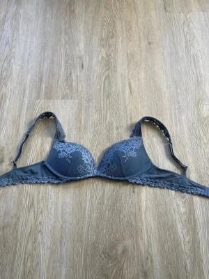 Intimissimi bh  - Snygg blå bh med vadderade kupor och vacker spetsdetalj över hela framsidan och axelbanden. Justerbara axelband och hakknäppning bak. Perfekt för dig som gillar en feminin och stilren look.