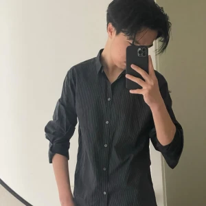 Svart randig skjorta från Tailor - Snygg svart skjorta från Tailor med tunna vita ränder. Skjortan har klassisk stil och passar perfekt inför sommar! Är helt ny men använt innan. Kontakta vid frågor eller pris! 